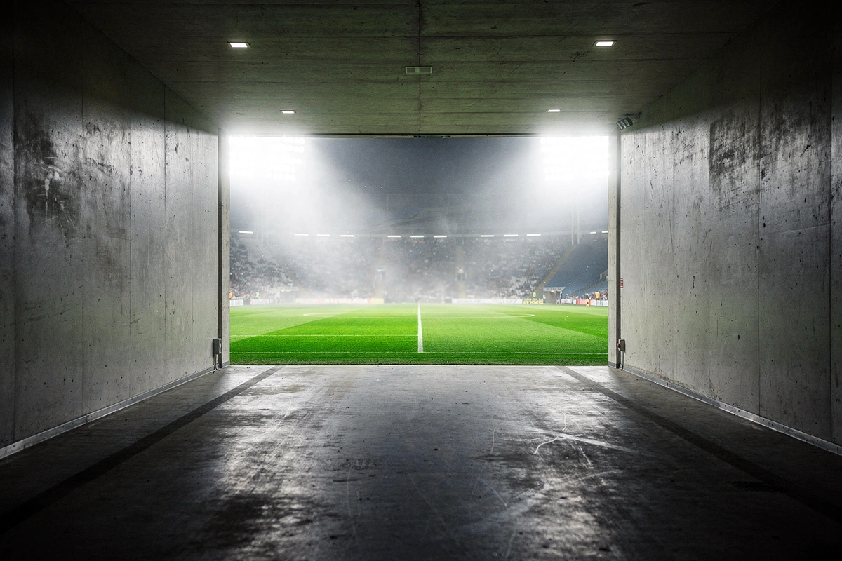 Blick aus dem Spielertunnel auf das beleuchtete Spielfeld